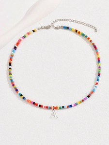 Dettaglio della collana di perline colorate con pendente lettera A argento e chiusura a moschettone