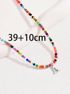 Dettaglio macro della collana di perline colorate con ciondolo lettera A e catena 39+10cm