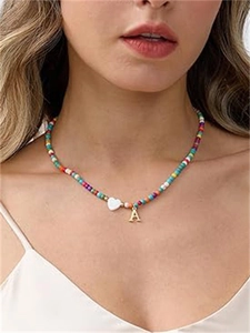 Dettaglio della collana di perline colorate con cuore bianco e ciondolo lettera A dorata