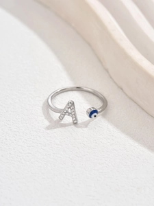 Dettaglio anello regolabile argento con lettera A di cristallo e motivo occhio blu
