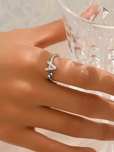 Dettaglio dell'anello regolabile in argento con lettera A e occhio blu al dito