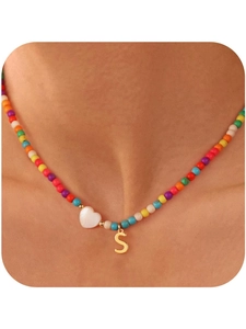 Dettaglio collana di perline colorate con cuore in conchiglia e ciondolo lettera S oro