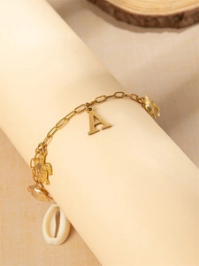 Detail van een gouden bedelarmband met zeeschildpad, dolfijn en letter A hanger
