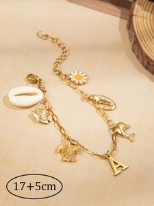 Detailweergave van gouden oceaanarmband met dolfijn- schildpadhangers en de letter A