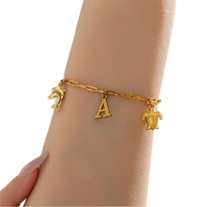 Gouden oceaan armband met dolfijn, schildpad en letter A bedeltjes om een pols gedragen