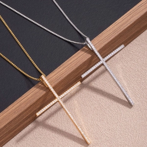 Detailed macro of gold and silver cross necklaces with micro-set zircon on wooden board