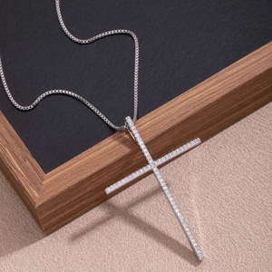 Detailed view of a silver cross pendant necklace with micro-pave cubic zirconia crystals