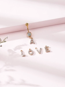 Detail of gold belly ring with large zircon and dangling crystal-encrusted letters A L O V E