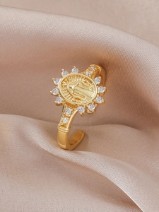Detail shot of a golden religious ring featuring Virgin Mary relief and white zircons