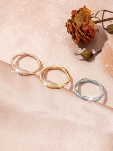Detailed macro view of three interlocking rhinestone rings in gold, silver, and rose gold