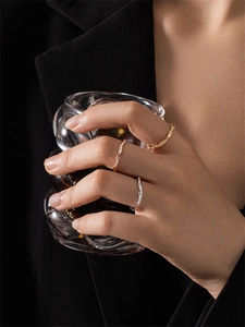 Detailed view of three stackable rope rings in gold, silver, and rose gold with small diamonds