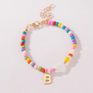 Detailweergave van de kleurrijke kralenarmband met hartkraal en gouden hanger letter B