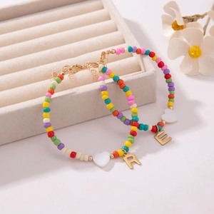 Kleurrijke kralen armband set met gouden letters R en E en witte hartjes bedeltjes
