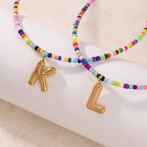 Collane di perline colorate fatte a mano con ciondoli a lettera dorati in stile boho