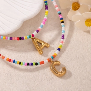 Collana boho con perline colorate e ciondoli a lettera A e C dorati in rilievo