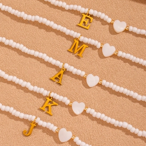 Elegante weiße Perlenketten mit goldenen Herzanhängern und Buchstaben-Anhängern
