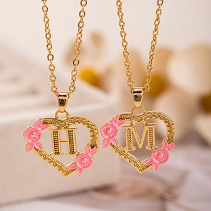 Collana a cuore dorata con fiori in smalto rosa e ciondolo con iniziale H o M