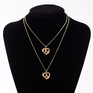 Collana elegante con cuore floreale e iniziali A e K su supporto di velluto nero