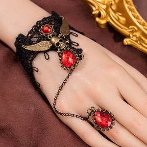 Gothic lace slave bracelet featuring bronze skull charms and a red teardrop gemstone