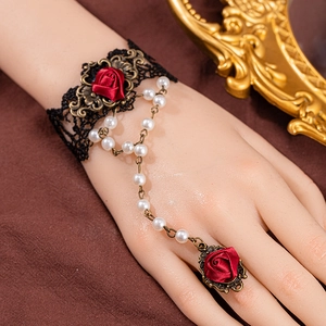 Gothic black lace bracelet with red rose ring and white pearl chain detail on hand