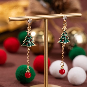Orecchini ad albero di Natale con smalto verde e perle rosse su supporto festivo