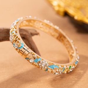 Vista dettagliata del bracciale vintage in oro traforato con smalto blu e strass chiari