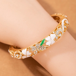 Elegante bracciale rigido dorato con fiori e farfalle traforati, smalto e zirconi