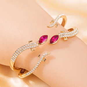 Détail d'un bracelet lézard doré avec cristaux roses et pierres pavées brillantes