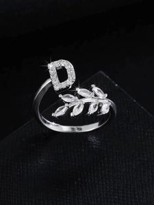 Anello aperto lettera D in argento con foglia di zircone su scatola di gioielli nera