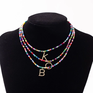 Collier bohème à trois rangs avec perles colorées et pendentifs KOB dorés sur buste