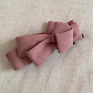 Detail of multi-layer dusty pink suede bow hair clip with black banana clip base