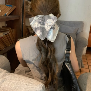Barrette nœud géant argenté métallisé avec rubans sur une queue de cheval femme