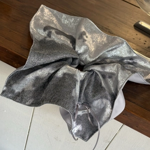 Vue détaillée du chouchou argenté en tissu métallisé avec une texture brillante et lisse