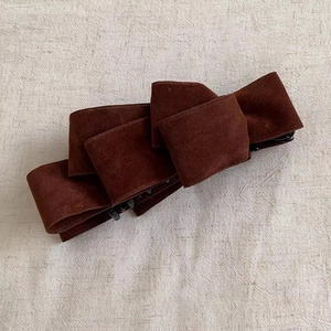 Detail of dark brown suede multi-layer bow banana clip with black plastic teeth