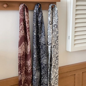 Trois foulards en soie vintage à motif paisley en rouge, bleu marine et crème sur bois