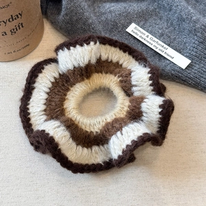 Détail macro d'un chouchou fait main au crochet avec motifs ondulés marron et beige