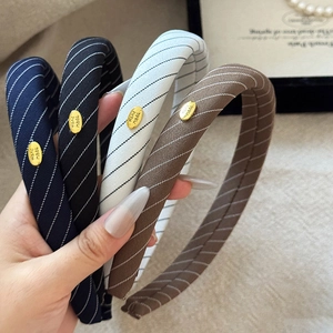 Set of four striped wide sponge headbands in navy black white and brown with gold logo