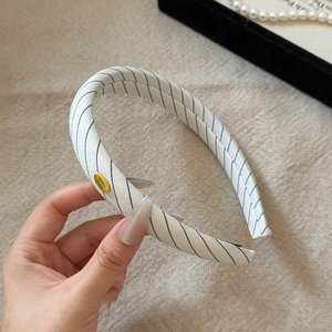 Retro white sponge headband with black twill pattern and gold handmade metal tag
