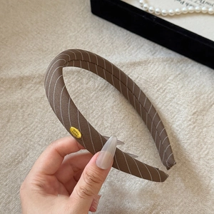 Detail of coffee brown twill sponge headband with Hand Made gold metal plate tag
