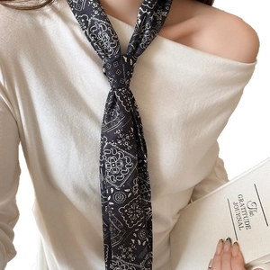 Écharpe fine noire avec motifs Paisley blancs vintage portée élégamment au cou