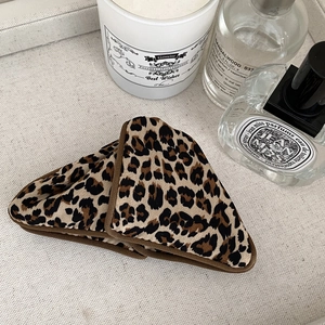 Detailed view of vintage leopard print triangular hair claw clip with bow on linen fabric