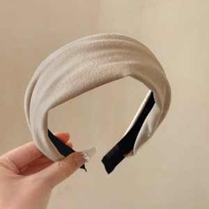 Detail of a beige velvet-textured headband with a wide-brim design and non-slip lining