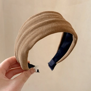 Detail view of brown pleated velvet headband with non-slip inner fabric texture