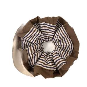 Brown and blue striped fabric oversized scrunchie for hair styling in a minimalist design