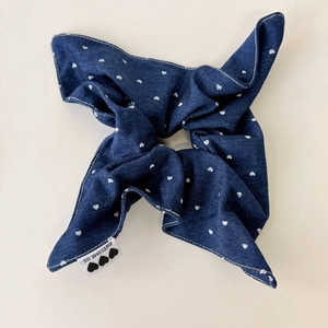 Close-up of blue denim scrunchie with heart pattern and white stitching detail