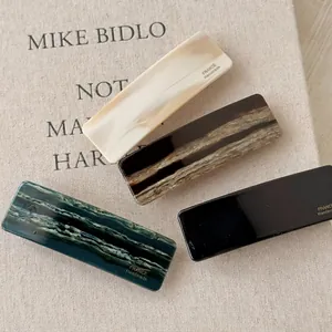 French vintage acetate hair clips set in marble and solid colors on a book cover