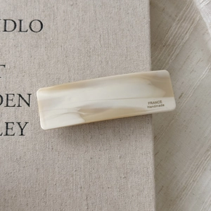 Macro view of cream marble acetate hair clip with France Handmade text detail