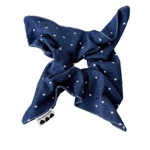 Blue denim scrunchie with white heart pattern and branded tag on white background