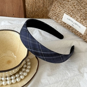 Detailed view of navy blue plaid fabric headband with non-slip lining and wide design