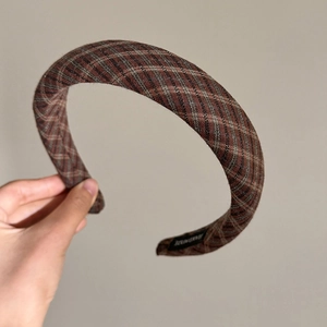 Detailed view of plaid sponge headband featuring a hand-made woven label on the side
